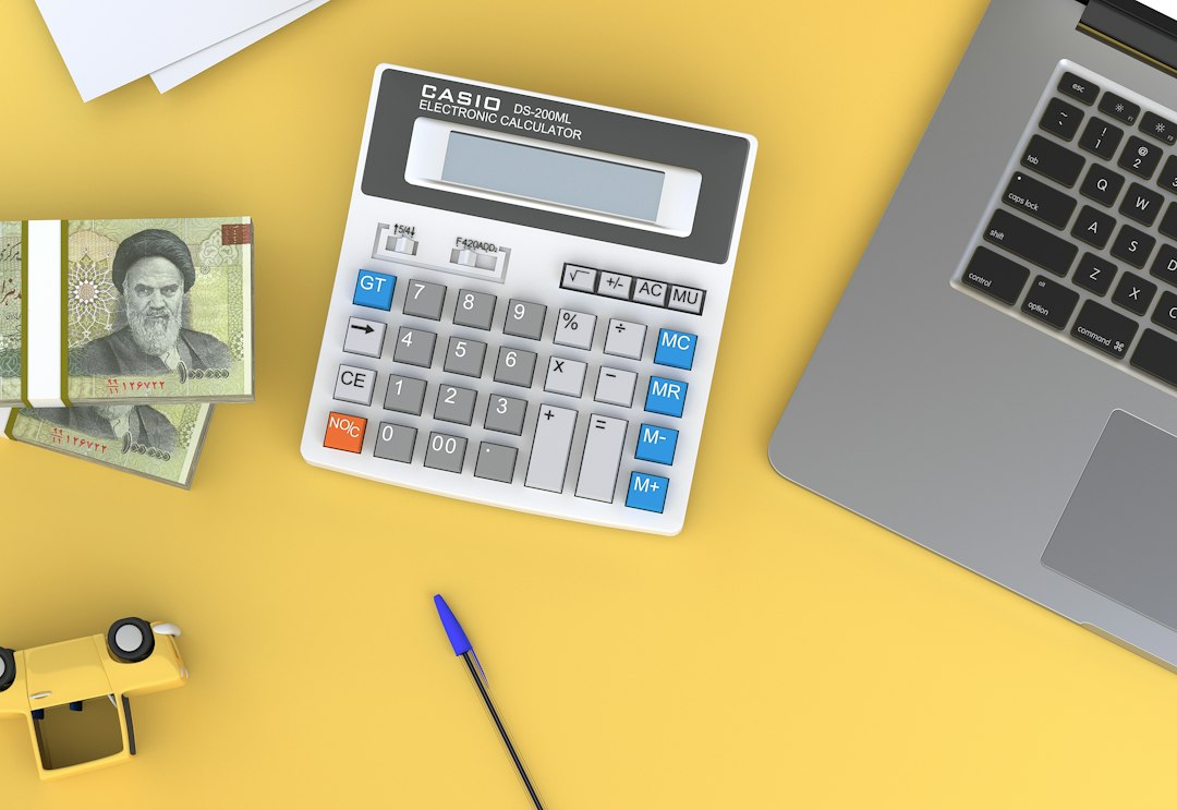 Small business cash flow planning with calculator and laptop